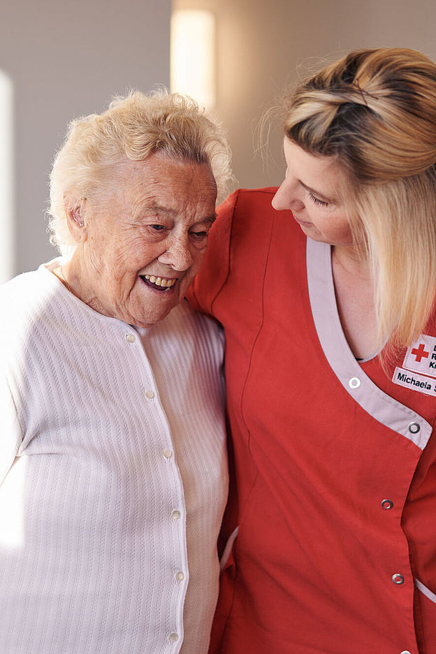 Ambulante Pflege Oschersleben Eine Pflegekraft hilft einer älteren Dame in den Rollstuhl